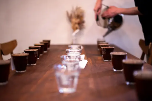 コーヒーの酸味
今回は取り沙汰されることの多いコーヒーの酸味のお話。
Encore! Coffee Roasteryでは浅煎りから深煎りまでラインナップしていますが、どんな焙煎度のコーヒー豆にも一定量の酸味があります。
詳しい成分などの難しい話は今回は置いておいて、ざっくり書きますね。
ある程度の良質な酸味は美味しいコーヒーになくてはならない要素の一つです。
また、逆にどんな浅煎りのコーヒー豆にも一定量の苦味もあります。火を加えている以上、苦味成分の形成(そして酸味成分も)は避けられません。
要はバランスが大切で、適正な濃度感で抽出した時に「酸味」「甘味」「苦味」の総和が心地良いものであれば、結果オーライです。
豆によって1:1:1の場合もあるし、2:1:0.5の場合もある。
うちのコンセプト的には深煎りも苦味は少なく焙煎するけれど、その分、質感と甘味は膨らませてバランスを取っています。
ただ、コーヒーの酸味というと、やはりネガティブなイメージを持たれている方が多いことも事実。
ここのすれ違いを僕らとしてはできるだけ無くしていきたいと思っています。
焙煎の失敗による生焼けのキツい酸味や、古い豆特有の口や胃がキューッとなる酸っぱい酸味とは分けて考えないといけないんだけれど、日本語だとどちらも「酸味」に一括りされがちなので、これが余計に混乱を招いている部分もあると思います。
もちろん、これは良質な酸味だから好きになれとか、分かるようになれとか押し付けるつもりは全然ないです。(そもそも当店のちはるさんはビターなマンデリンが一番好きなのだそうです)
ただ、コーヒーの楽しみと選択の幅を広げるための一つの提案として知っていただけたら嬉しいなぁと。
シンプルに深くてビターなコーヒーの方が好みという場合もありますし、シトラス系の酸味は好きだけど、ベリー系の酸味は苦手といった場合もあると思います。
後はその味を経験した回数や体質の差もあります。
コーヒーは苦いものだという認識がある場合だったり、酸味を強めに感じる体質の方だったりすると、たとえ良質な酸味であっても酸っぱいと感じたりします。僕も昔は前者でした。
お酒もそんな感じかもしれない。
ただ、この時に感じる酸味が例えばフレッシュなフルーツを連想させるものだったり、甘味を含んだものだったりすればそれは良質な酸味と言っていいと思います。
例えばリンゴをシャクっと齧ったときに感じる甘く爽やかな酸味や、柑橘類を食べたときに感じる瑞々しい酸味。
一言で言えば「甘さを含んで明るい印象」があるかどうか。
口に含んでいるときに心地よさを感じて、次の一口を飲みたくなるかどうか。
こういう良質な酸味と心地よいバランスを持つコーヒーを僕らは目指して焙煎しています。
まだまだ僕たち自身、技術も味覚も磨いている最中です。
みなさんと一緒により美味しいコーヒーを目指していけたらと思います！
ーーーーーーーーーーーーーーー
【OUR CONCEPT】
Encore! Coffee Roasteryのコーヒーは4つのことを念頭に焙煎、味作りをしています。
◯新鮮であること。
◯苦味が少ないこと。
◯甘みを感じること。
◯飲み疲れないこと。
「一杯の感動をもっと日常に」———
ぜひ私たちのコーヒーを日々の生活のパートナーとして感じてほしいと思います。
【事業者さま・お店のオーナーさまへ】
当店の焙煎したコーヒー豆を使ってくださる卸販売のパートナーさまを随時募集してます。
現在様々な業種業態で数多くのお店さまやオーナーさまに使っていただいてます。
○当店ができることの一例
・オリジナルブレンドの開発
・オリジナルドリップバッグの製造
・マシンの導入サポートやコーヒー関連器具、消耗品の卸販売
・スタッフさま向けの抽出トレーニングの実施
・開業サポート
コーヒー豆をお渡しして終わりではなく、ともにお客様への最高の一杯を作りあげていけるパートナーとして、ぜひ私たちのコーヒーをお使いください。
ーーーーーーーーーーーーーーー
Encore! Coffee Roastery | アンコールコーヒーロースタリー
最新の営業日時など店舗情報・オンラインショップはプロフィール画面から
@encore_coffee_roastery
ーーーーーーーーーーーーーーー
#encorecoffeeroastery #アンコールコーヒーロースタリー #焙煎  #コーヒーショップ #スペシャルティコーヒー #specialtycoffee #コーヒー #coffee #coffeelover #コーヒータイム #コーヒーライフ #大阪カフェ #大阪コーヒー #城東区コーヒー #城東区カフェ #コーヒーのある暮らし#osakacoffee #osakacafe